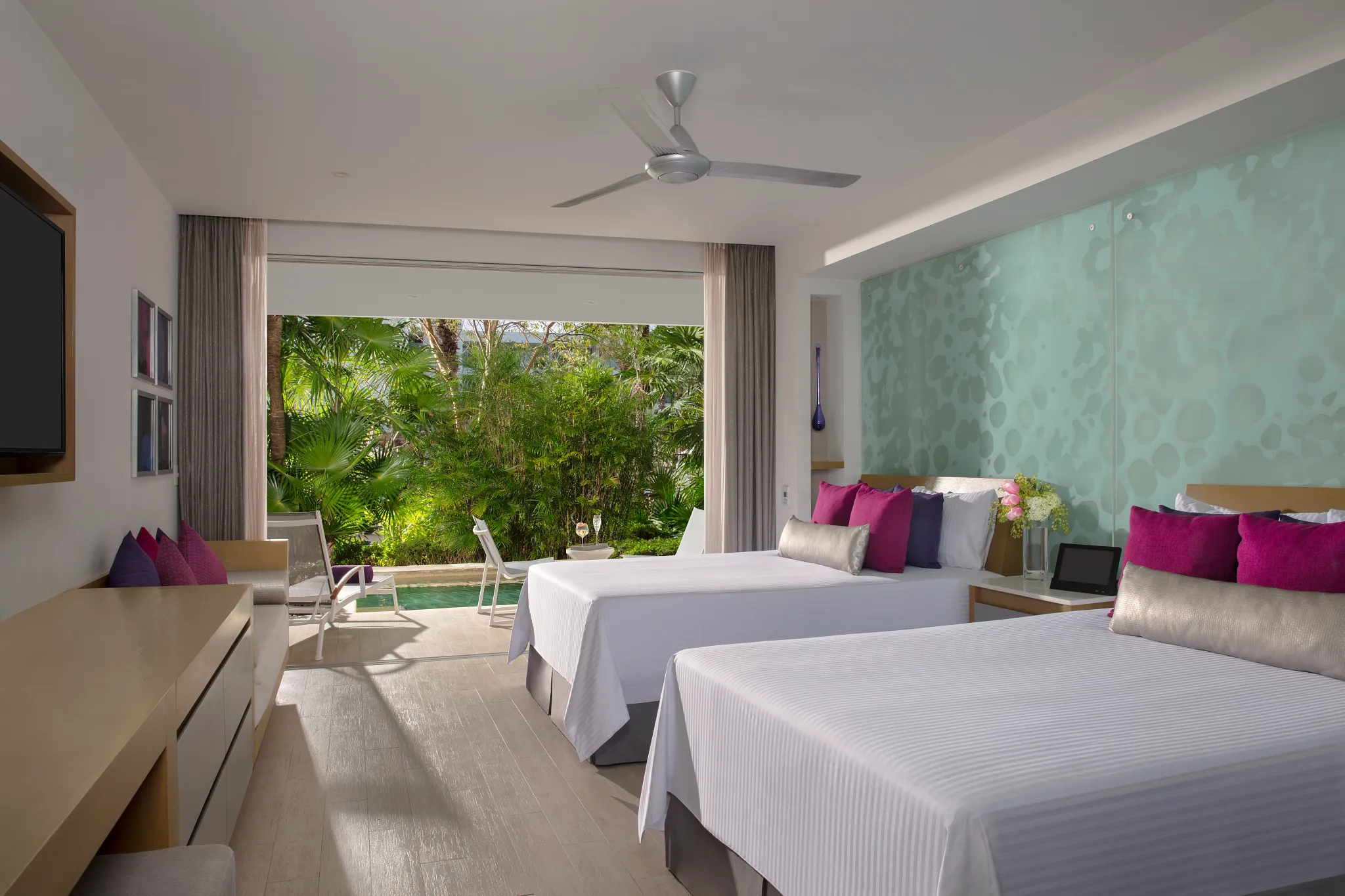 Xcelerate Junior Suite Swim Out Tropical View interior at Breathless Riviera Cancun with double beds, modern seating area, and open-concept layout.
