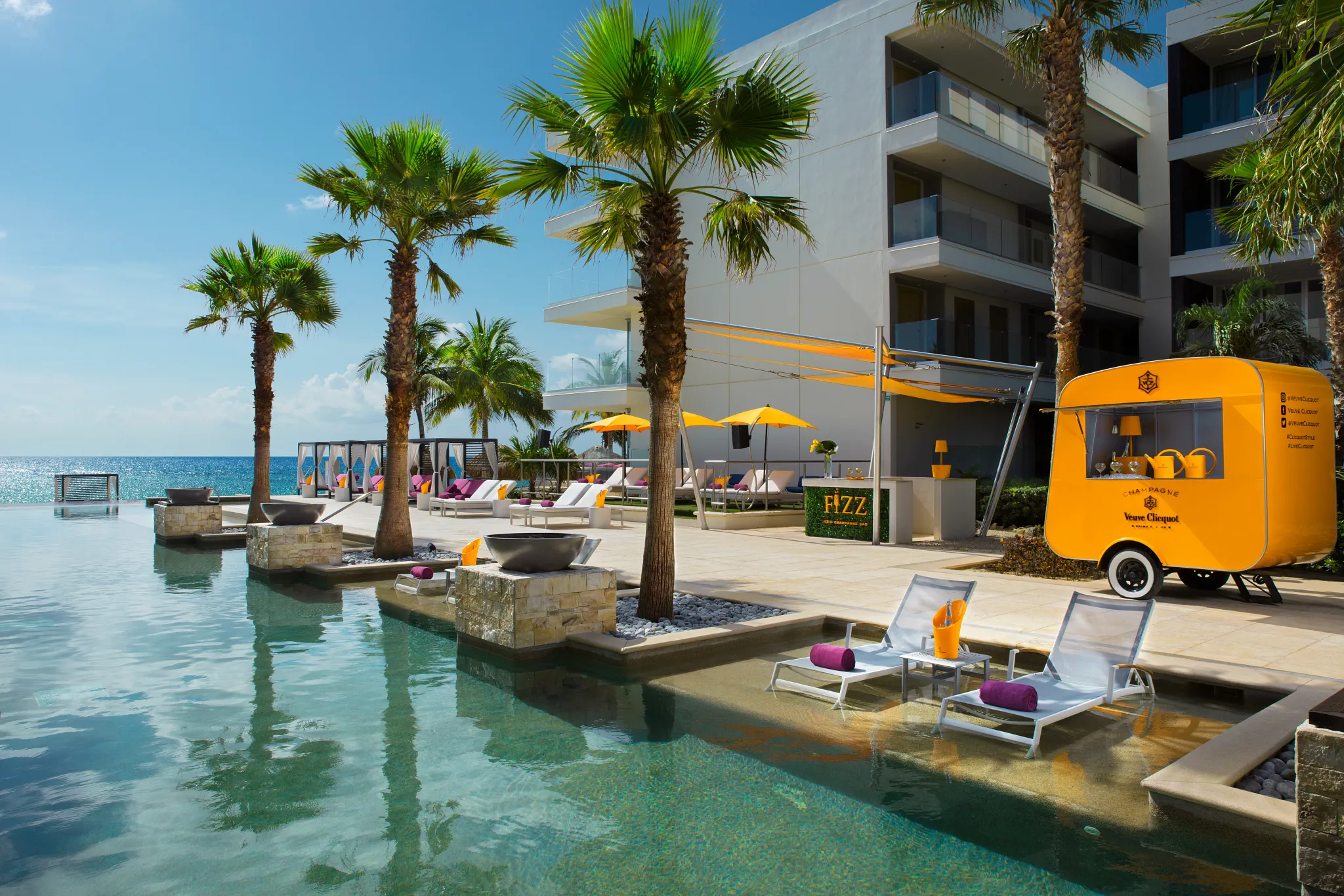 Fizz Champagne Bar cart and poolside loungers overlooking the ocean at Breathless Riviera Cancun.