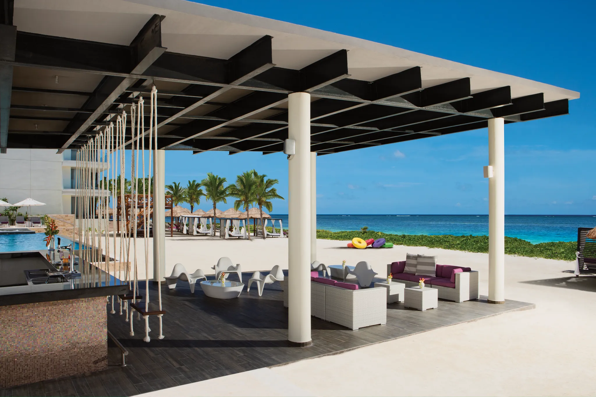 Beachfront Foam Bar at Breathless Riviera Cancun featuring swing seating, ocean views, and a relaxed tropical vibe.