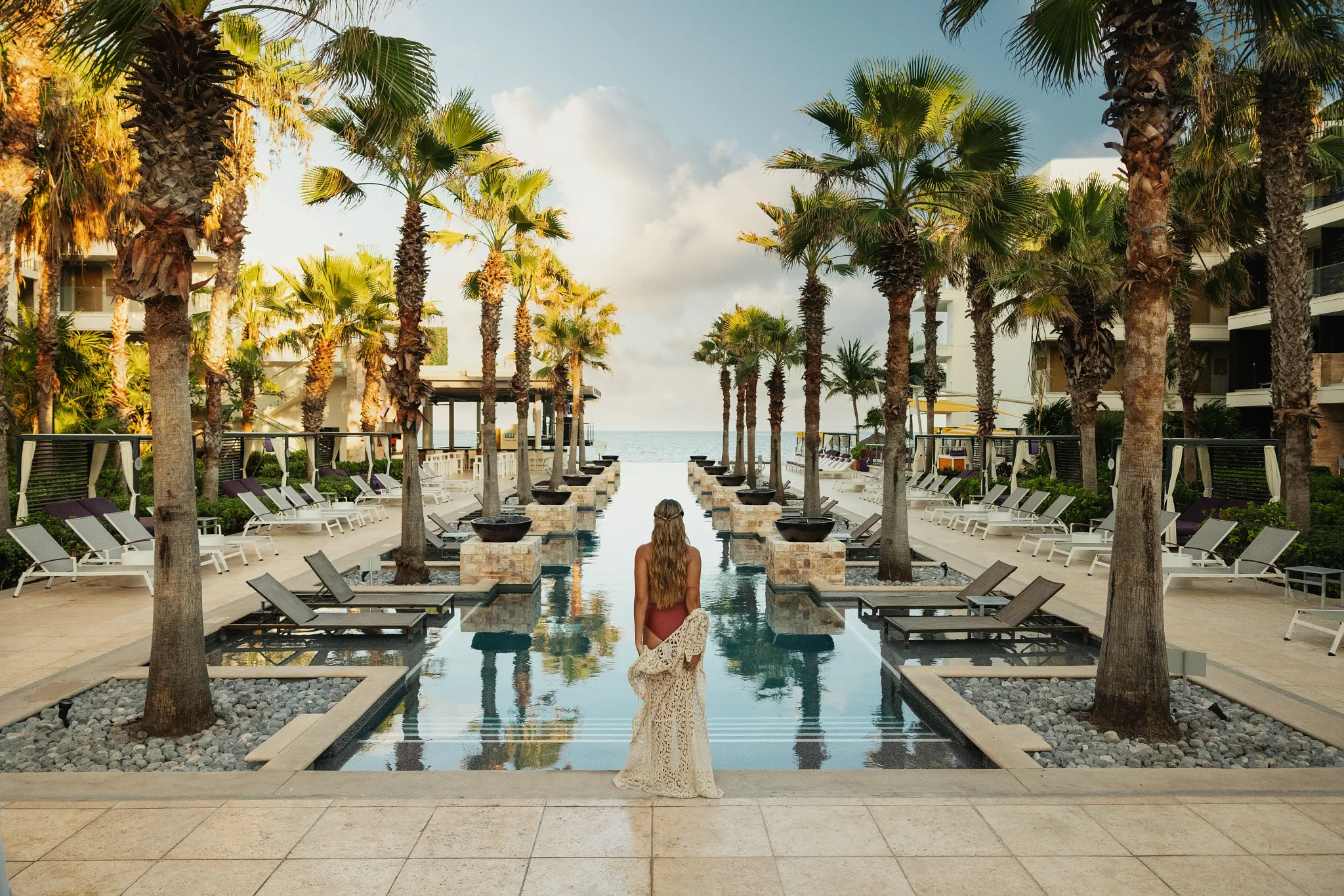 A woman looking over the Xcelerate Pool at Breathless Riviera Cancun, known for its upbeat music, social scene, and energetic vibe.