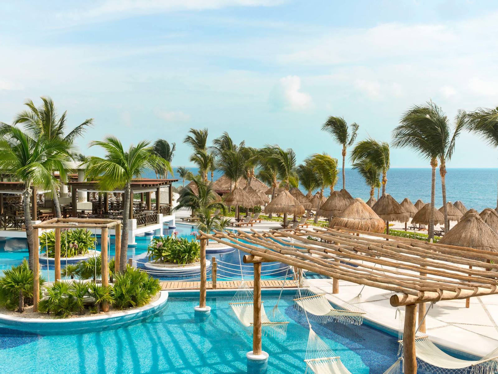 Excellence Playa Mujeres adults-only all-inclusive resort with oceanfront pools, palm-lined beachfront, and luxury suites in Cancun, Mexico.