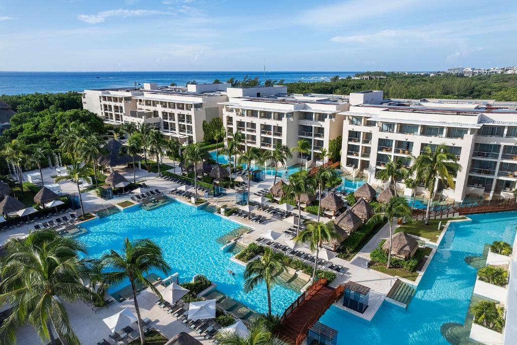 Paradisus La Perla Riviera Maya adults-only resort with lagoon-style pools, palm-lined walkways, and luxury accommodations near Playa del Carmen.