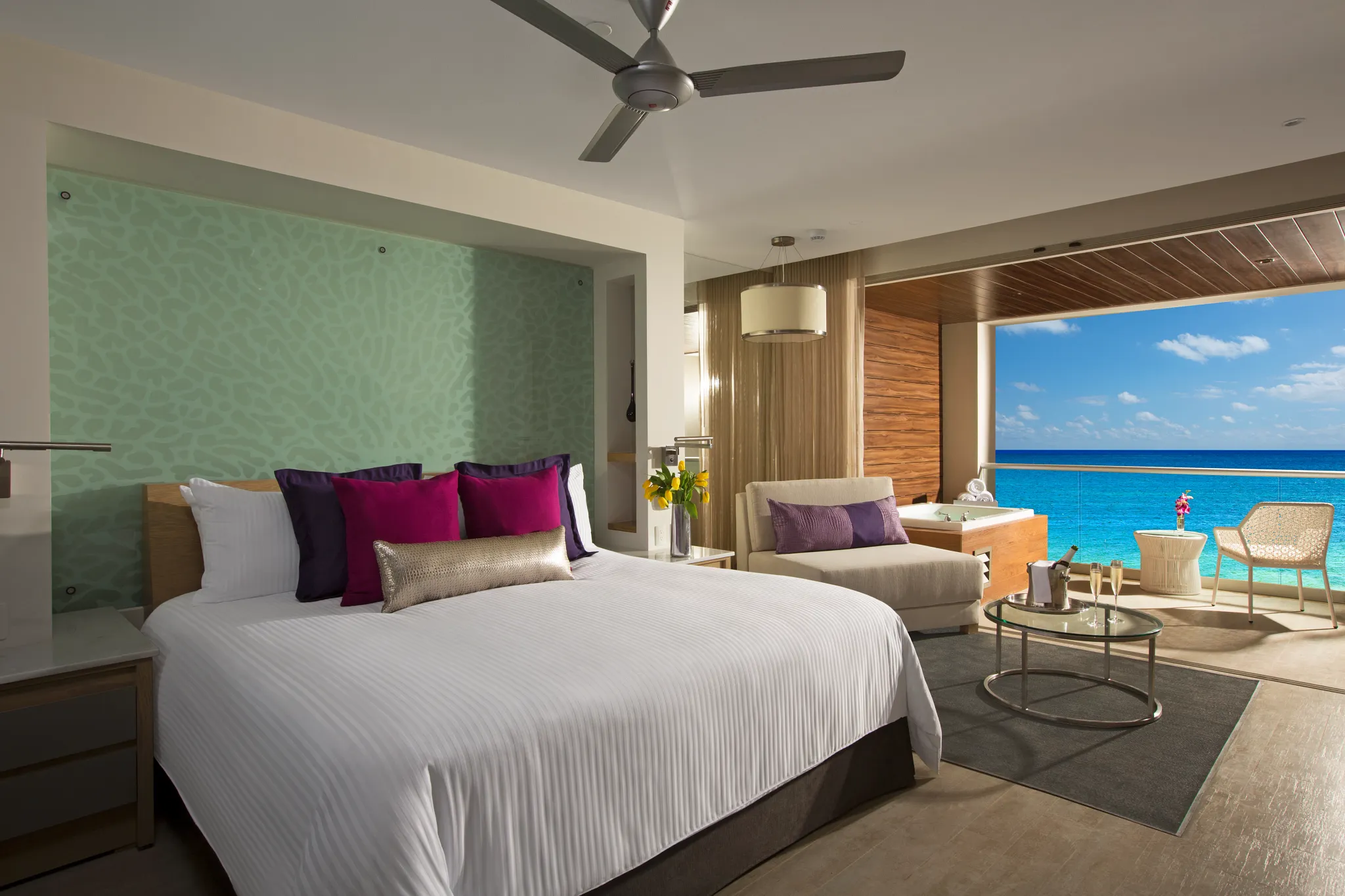 King-bed bedroom in the Xhale Club Junior Suite Ocean Front Whirlpool at Breathless Riviera Cancun with oceanfront views, modern décor, and plush bedding.