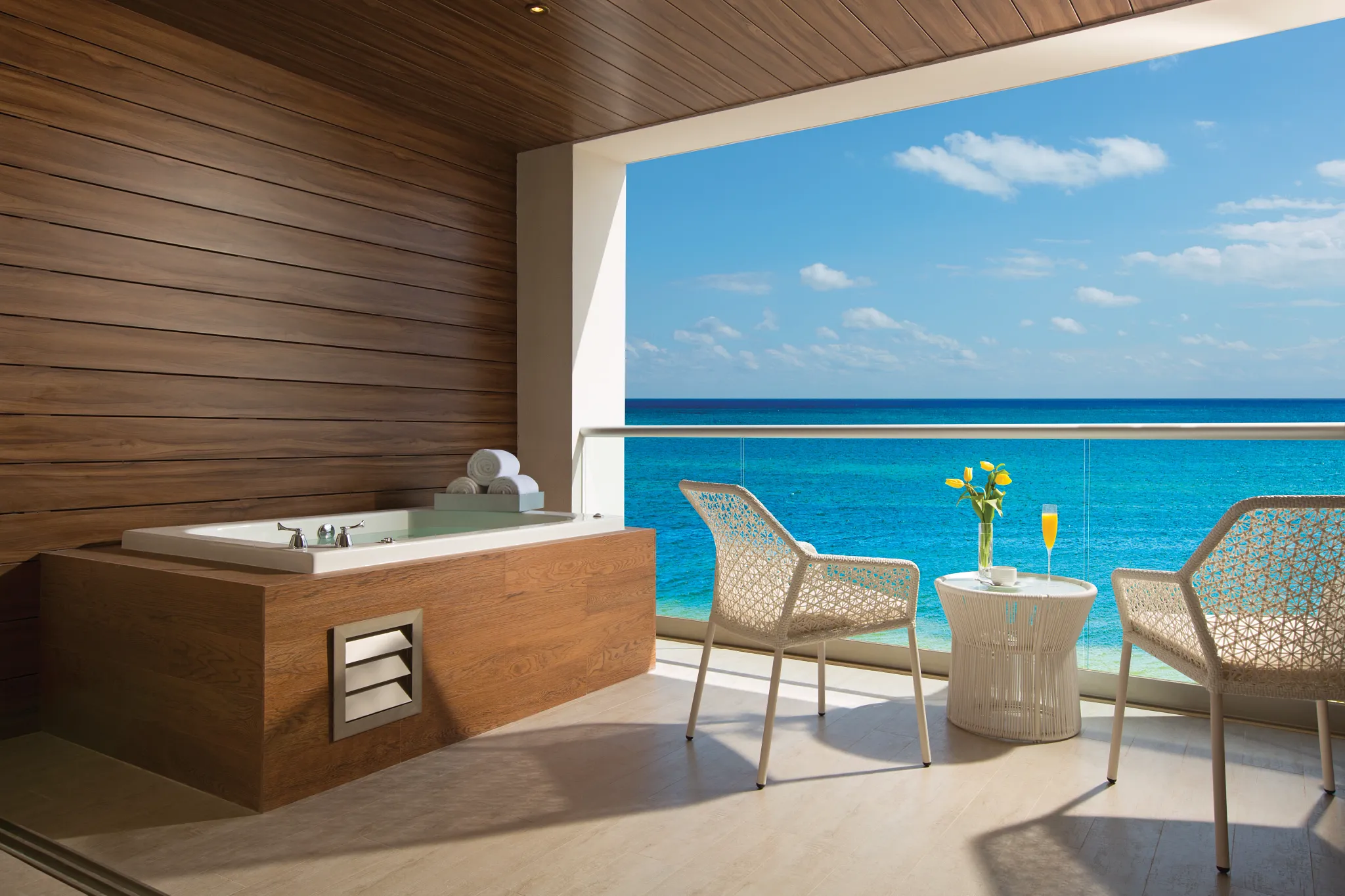 Private oceanfront terrace with whirlpool tub in the Xhale Club Junior Suite Ocean Front Whirlpool at Breathless Riviera Cancun overlooking the Caribbean Sea.