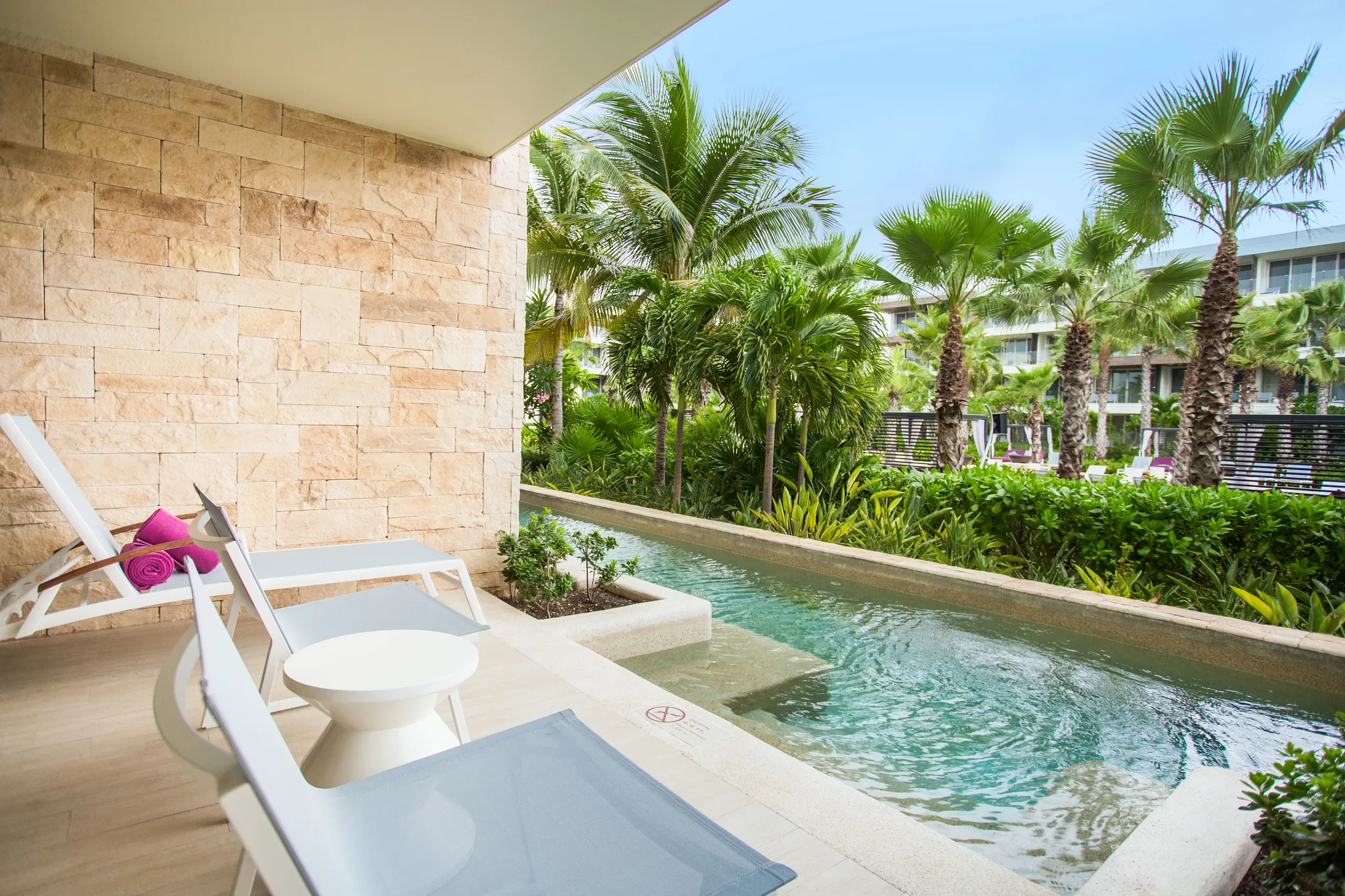 Xhale Club Junior Suite Swim Out Tropical View terrace at Breathless Riviera Cancun with direct pool access, lounge chairs, and tropical garden views.