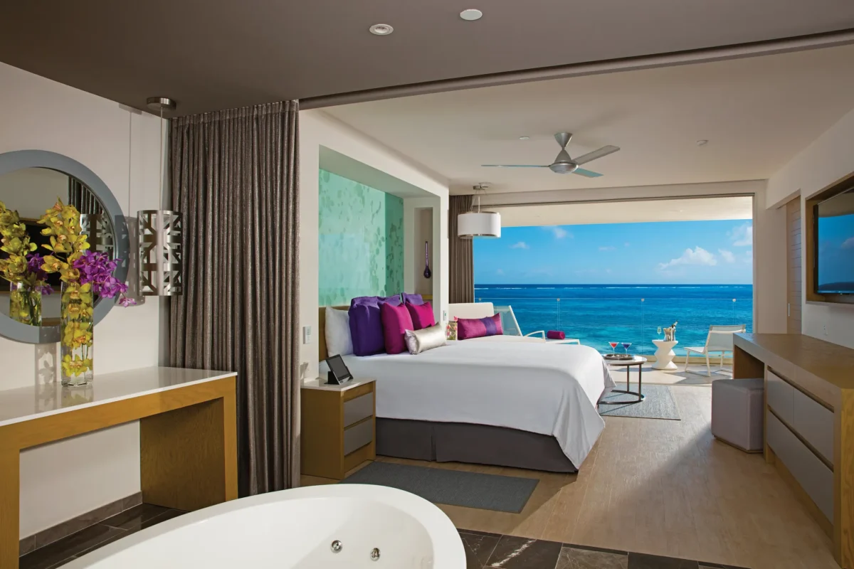 Xhale Club Master Suite Ocean Front bedroom at Breathless Riviera Cancun with king bed, stylish seating area, and panoramic ocean views.
