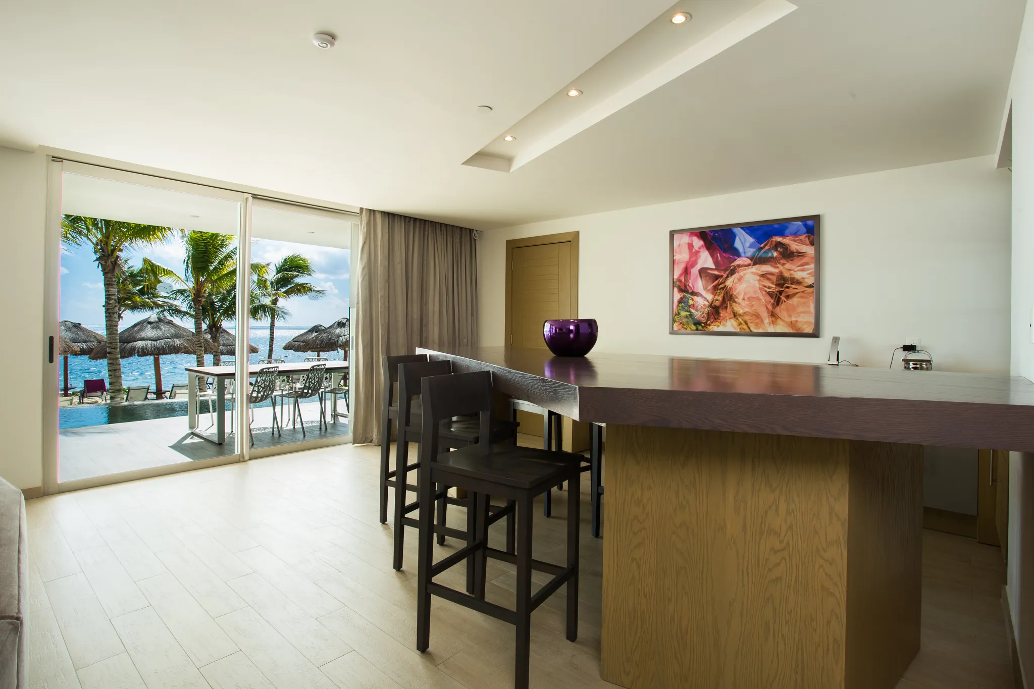 Living area and private bar in the Xhale Club Presidential Suite Swim Out Ocean Front at Breathless Riviera Cancun with modern furnishings and ocean-front terrace access.